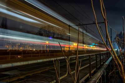 Train at railroad station against sky at night