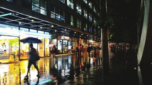 People walking in illuminated city at night