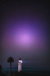 Lighthouse against sky at night