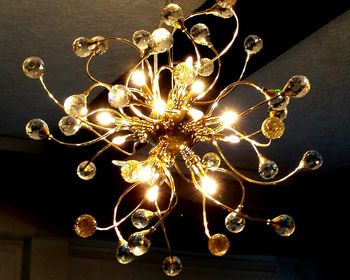 Low angle view of illuminated chandelier hanging from ceiling