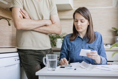 Young woman using mobile phone while sitting on table