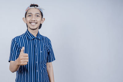 Portrait of smiling young man against blue background