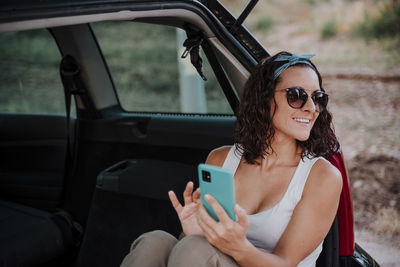 Midsection of woman using mobile phone while sitting in car