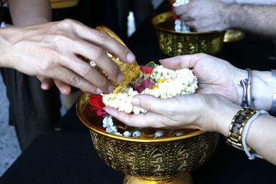 Cropped hands of people holding religious offerings