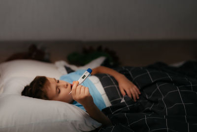 Sick child showing thermometer with high temperature. small dof, focus on the thermometer 