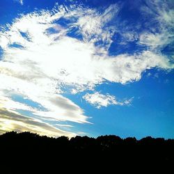 Silhouette of trees against cloudy sky