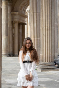 Portrait of woman standing in front of building