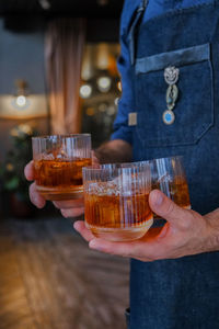 Midsection of man holding beer glass