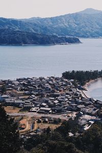 High angle view of townscape by sea against sky