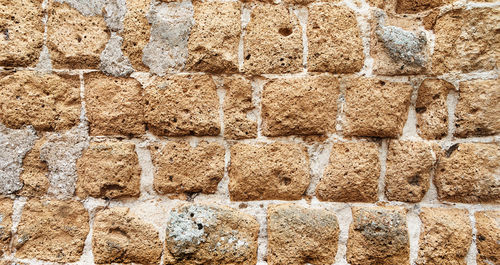 Pattern and texture close up of an ancient brick stone wall