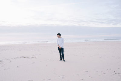 Man standing on sand at beach
