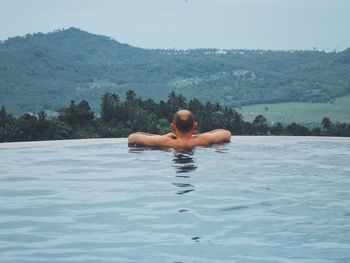 Full length of shirtless man swimming in pool