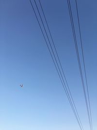Low angle view of airplane against clear blue sky