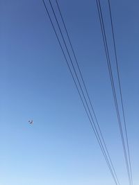 Low angle view of airplane against clear blue sky