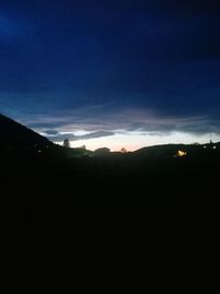 Silhouette landscape against sky at night