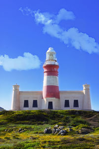 Lighthouse by sea against sky