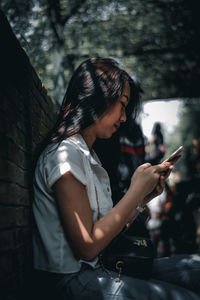 Midsection of woman using mobile phone outdoors