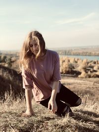 Young woman on land against sky