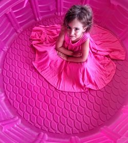 Portrait of girl in pink dress sitting in large tub