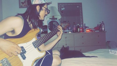 Woman playing guitar at home