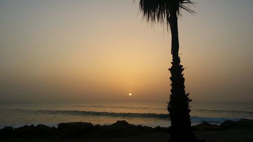 Scenic view of beach against sky during sunset