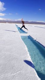 Man jumping in sea against sky