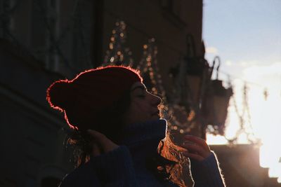 Low angle view of young woman with eyes closed against sky