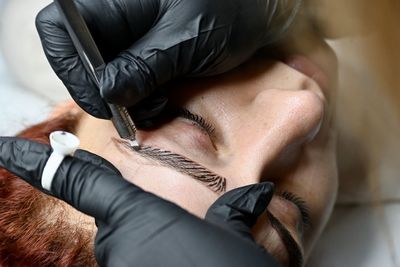 Young woman having her eyebrows micro blading 