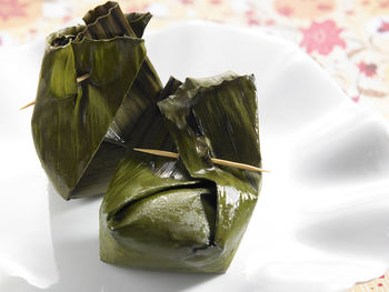 Close-up of food wrapped in banana leaves served in plate