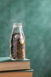 Close-up of coins in jar on books