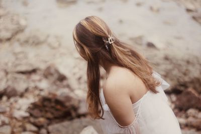 Side view of young woman standing at beach