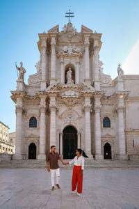 People outside temple against building