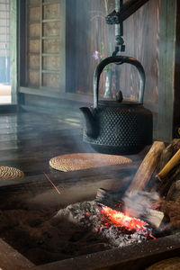 Close-up of teapot hanging over fire