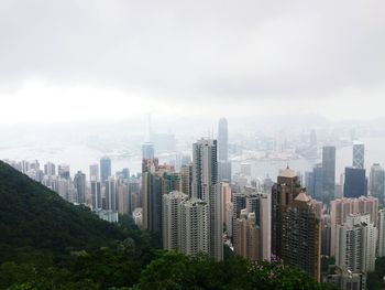 Aerial view of modern buildings with victoria harbour against sky