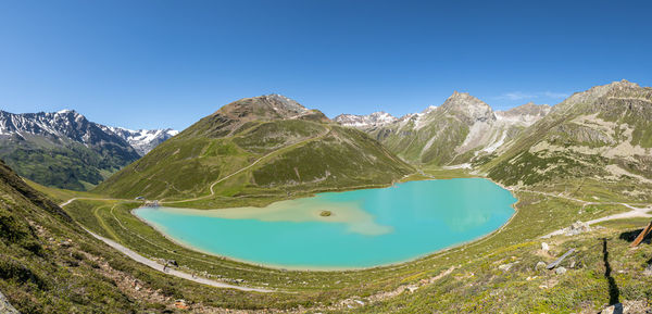 Panoramic view of lake and mountains against clear blue sky