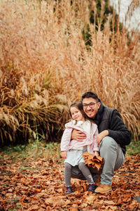 Portrait of a smiling young woman with autumn leaves