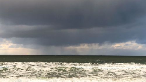 Scenic view of sea against storm clouds