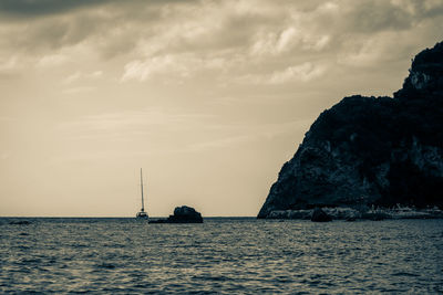 Sailboat sailing on sea against sky during sunset