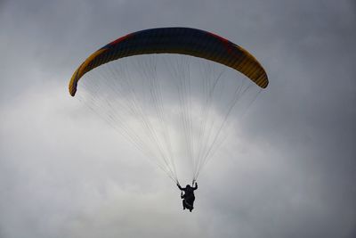 Person paragliding against sky