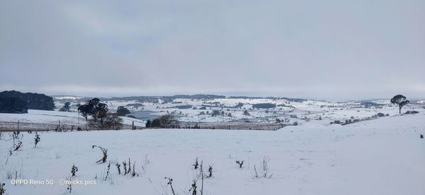 Snow covered landscape against sky