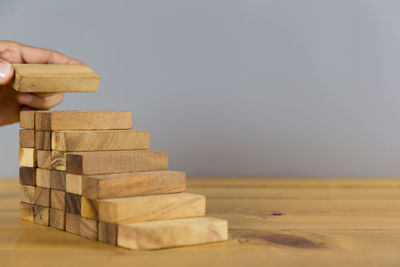 Close-up of hand holding stack of wooden table