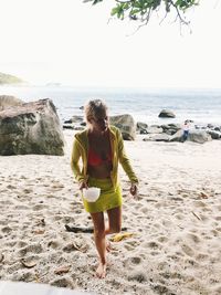 Full length of woman on beach against sky