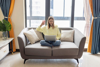 Woman sitting on sofa at home