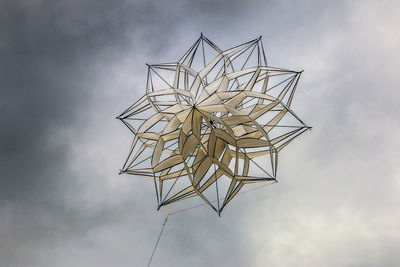 Low angle view of decoration against cloudy sky