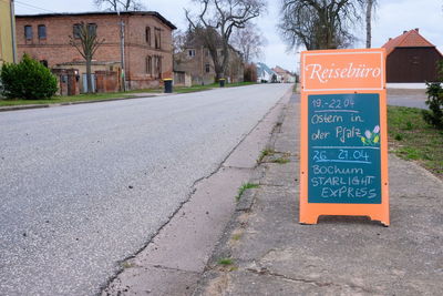 Information sign on road by building