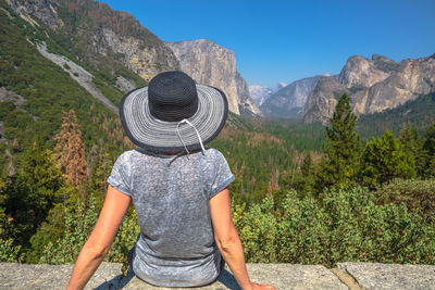 Rear view of person wearing hat against mountains