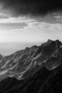 Scenic view of mountains against cloudy sky