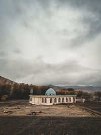 Built structure on field against sky