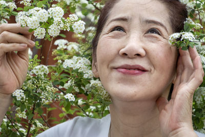 Portrait of smiling woman holding flowering plants
