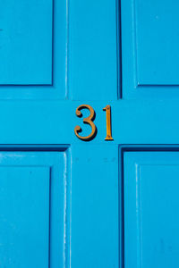 House number 31 on a blue wooden front door in london 